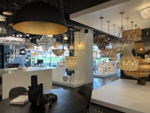 Step into our lighting showroom, where chandeliers and modern lamps illuminate a vibrant space. With brightly lit interiors and a palette of white and black walls, we showcase an impressive range of designs and styles for all your lighting needs.